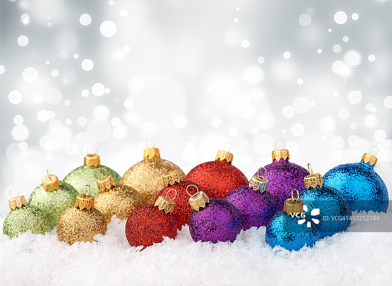 雪地上排列的彩色闪光装饰球图片素材
