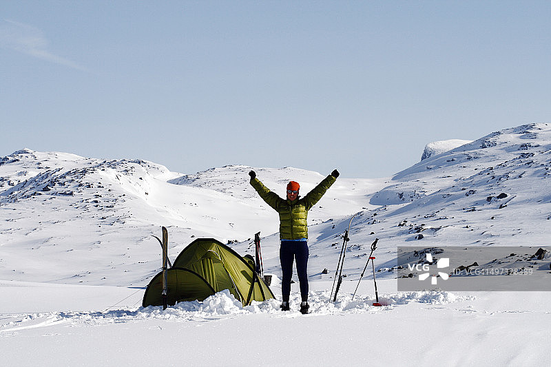 女人在冬季山区瑞克斯格伦森的帐篷旁，拉普兰，瑞典图片素材