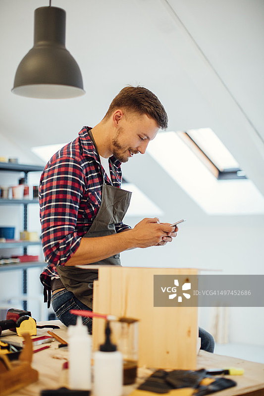 家具设计师在工作室使用智能手机图片素材