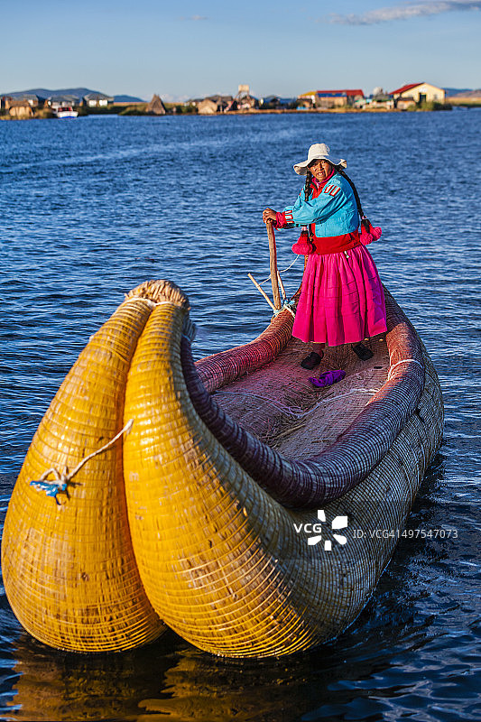 秘鲁妇女在的的喀喀湖乌罗漂浮岛屿之间航行图片素材