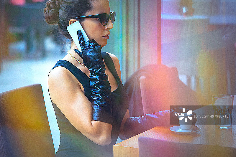 优雅女人在咖啡馆打电话图片素材