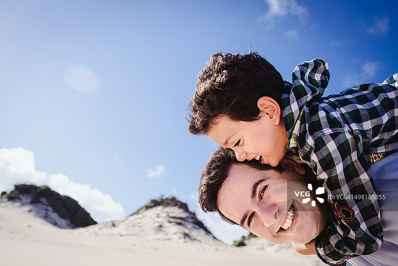 父亲让儿子坐在肩膀上玩耍图片素材