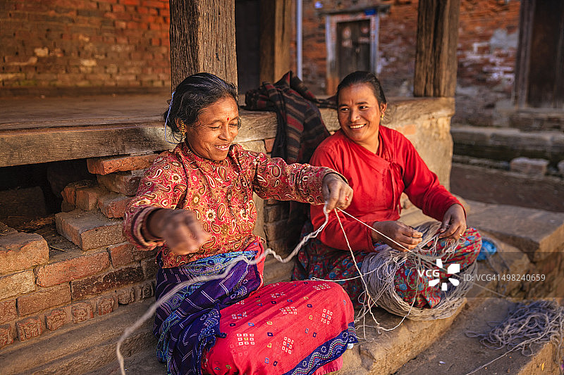 两位尼泊尔妇女在尼泊尔巴克塔普尔纺羊毛图片素材
