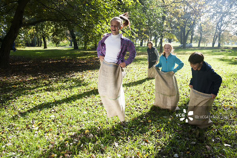 快乐的孩子们参加麻袋赛跑图片素材