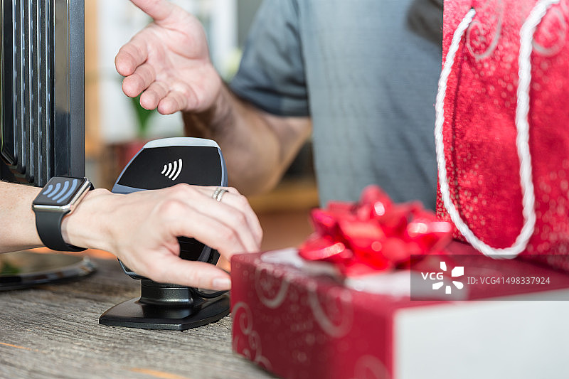女人在商店用智能手表NFC技术支付图片素材