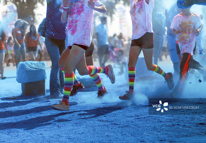 奔跑在蓝色染料中的彩色赛跑者图片素材