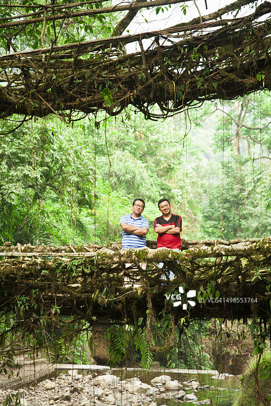 在印度热带雨林由藤蔓制成的古老桥梁上的游客图片素材