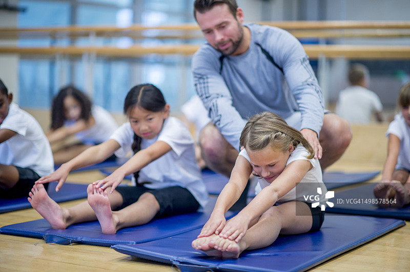 教孩子做拉伸运动图片素材