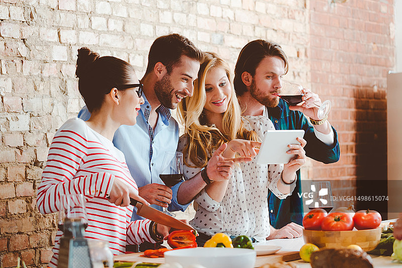 朋友在现代厨房用平板电脑烹饪图片素材