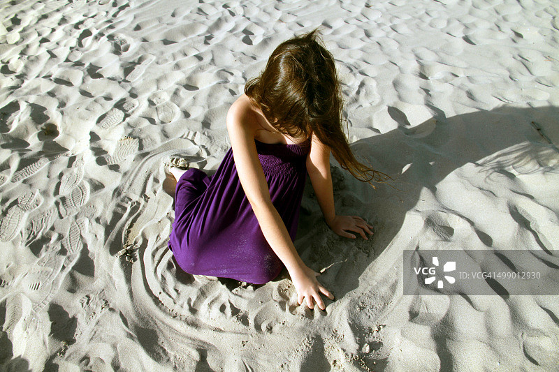 坐在海滩上的年轻女孩图片素材