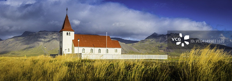 山脚下草地上的红色屋顶乡村教堂图片素材