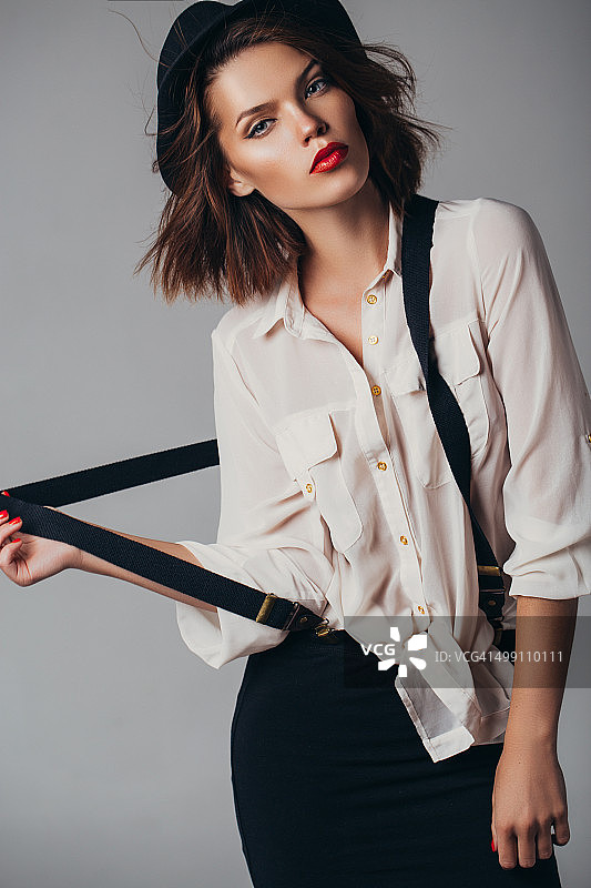 户外拍摄的戴复古帽的年轻漂亮女人图片素材