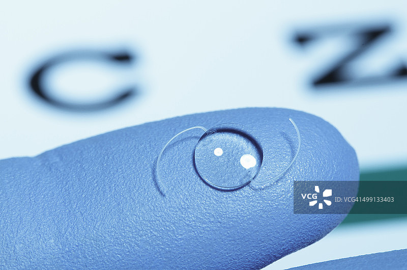 手套上的眼内晶状体：一种人造晶体，通过手术植入人眼中，用于提取因白内障而混浊的天然晶状体图片素材