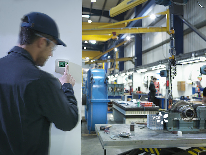 工厂工人调节恒温器图片素材