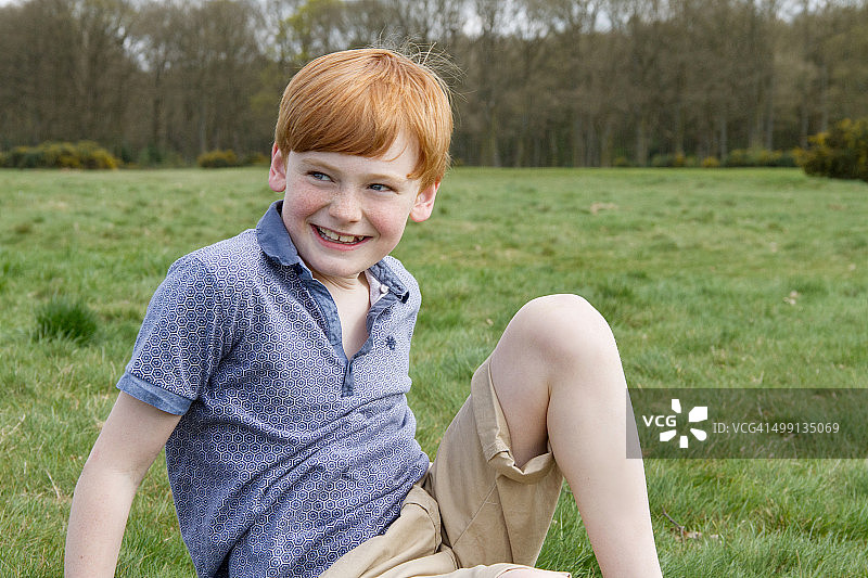 坐在田野里的男孩肖像图片素材