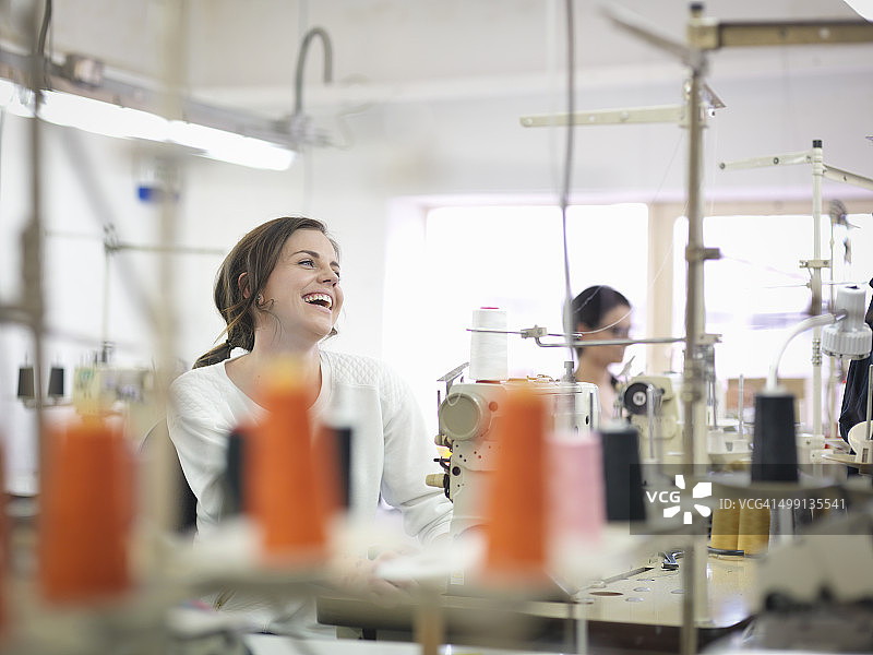 服装厂里笑着的女服装工人图片素材