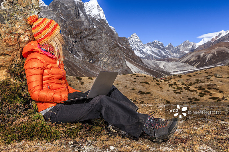 年轻女人在尼泊尔喜马拉雅山脉使用笔记本电脑图片素材