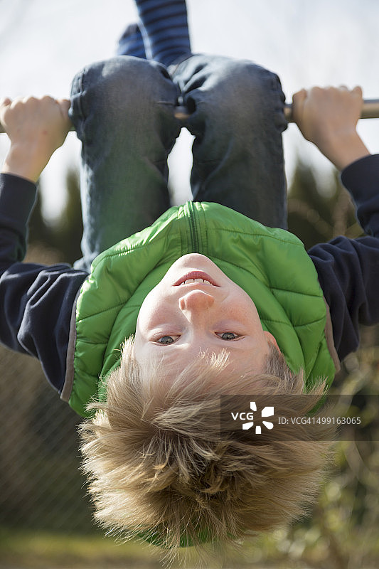 男孩在单杠上锻炼图片素材
