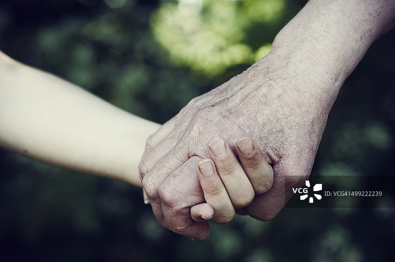 年轻女孩和祖母手牵着手图片素材