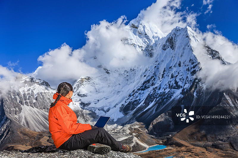 女人在尼泊尔珠穆朗玛峰国家公园使用笔记本电脑图片素材