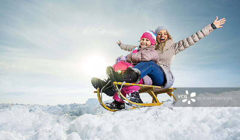 快乐的母女在雪地里滑雪图片素材