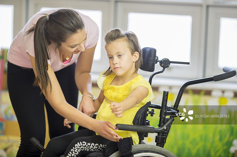 护理人员帮助儿童离开轮椅图片素材