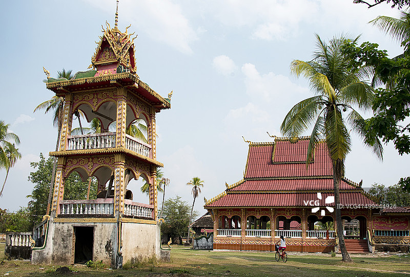 在老挝东德岛坤泰寺骑自行车旅行的女游客图片素材