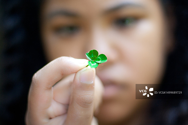 女孩手持四叶草图片素材