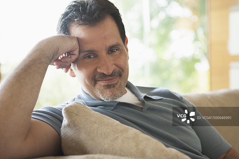 西班牙裔男人在沙发上放松图片素材