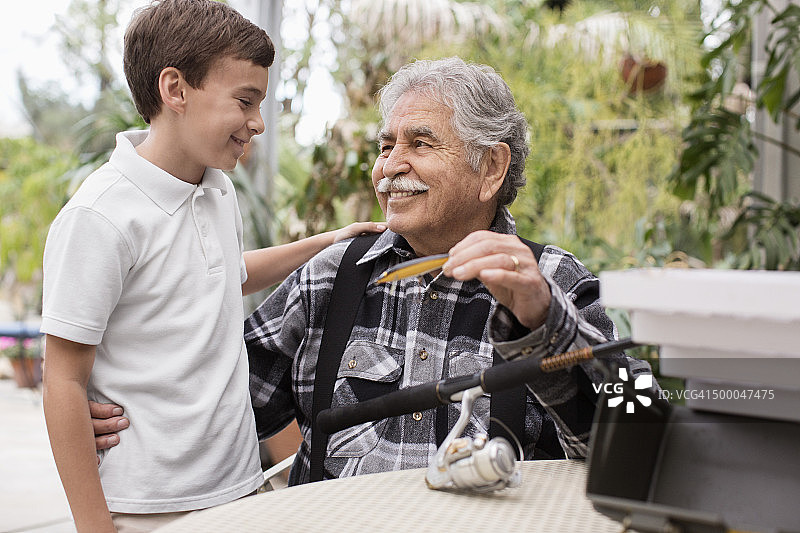 年长的白人男子和孙子检查钓鱼竿图片素材