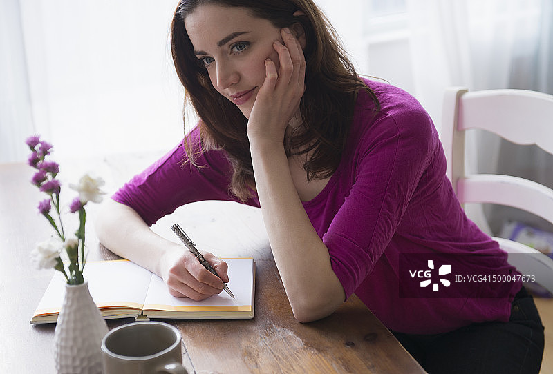 在桌前写日记的女人图片素材