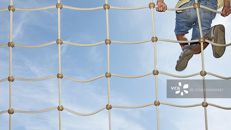 小男孩在攀爬网上（局部）图片素材