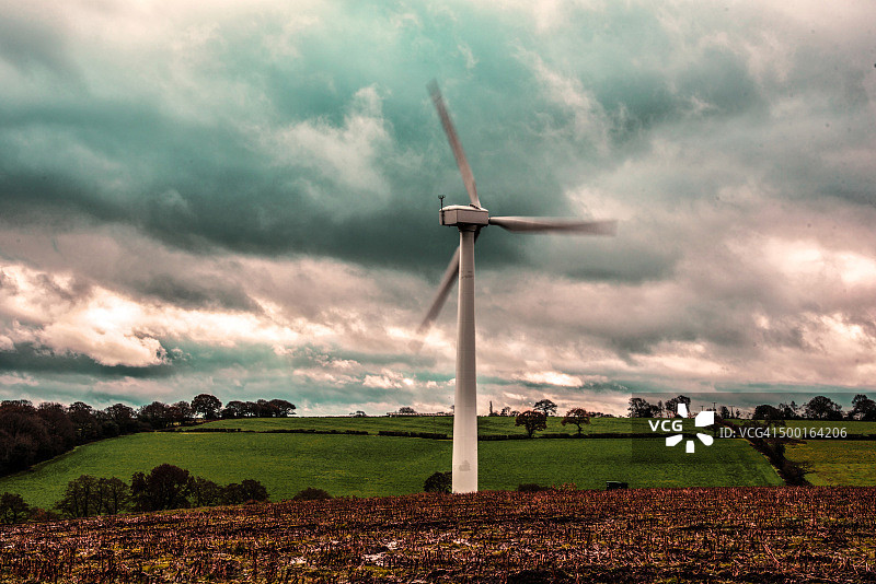 暴风雨天空下的单台风力涡轮机图片素材