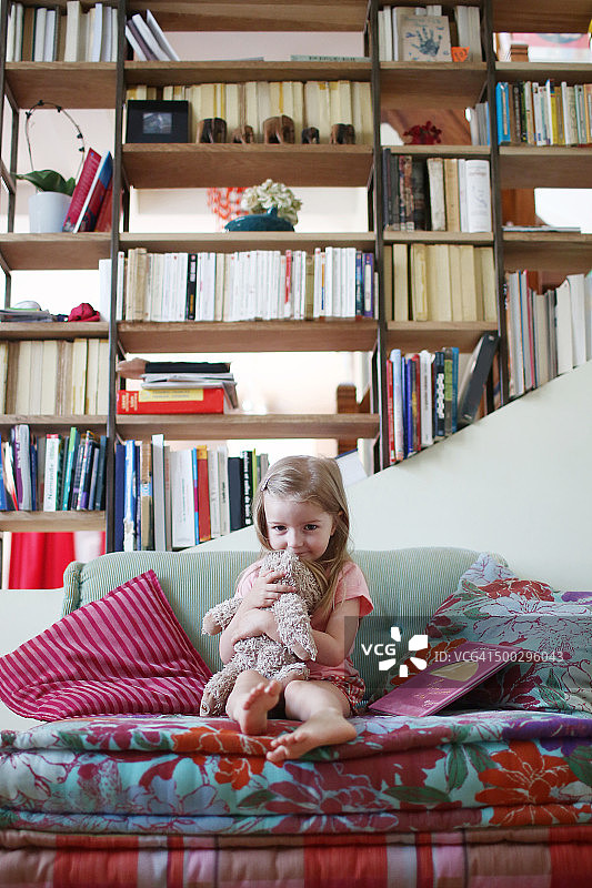 一个3岁的女孩抱着她的毛绒玩具图片素材