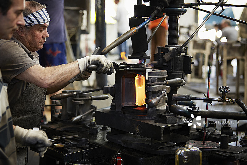 吹塑机旁的玻璃工人图片素材