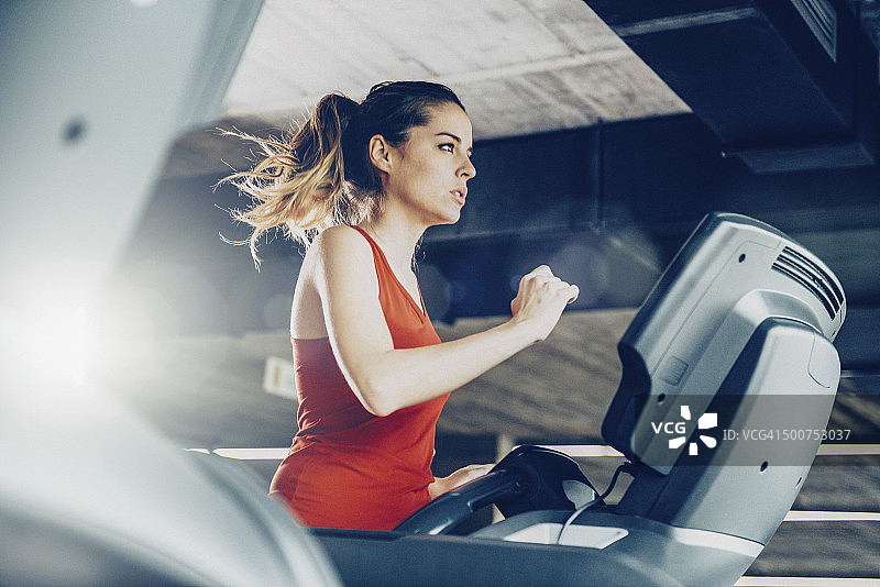 健康女性在跑步机上跑步图片素材