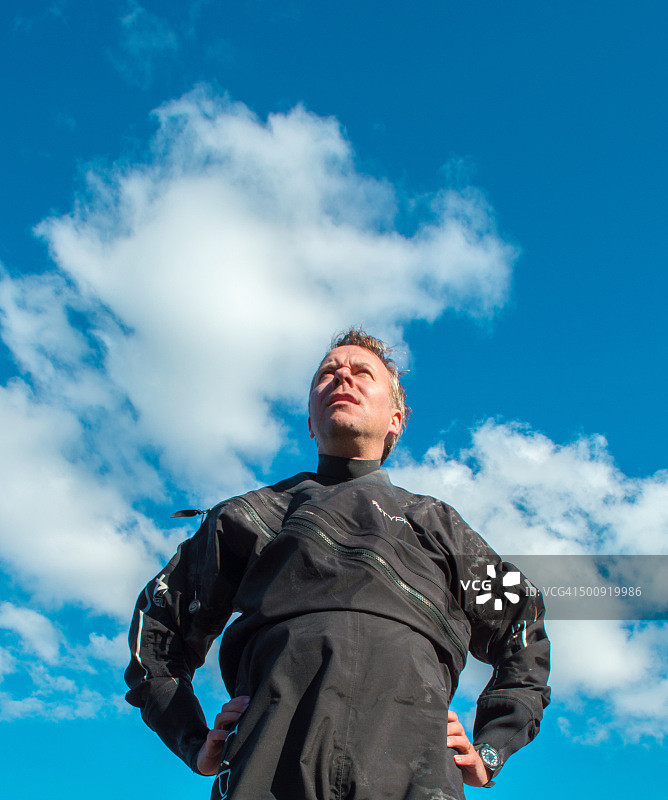 身穿防水服的皮划艇爱好者，背景是蓝天和蓬松的云朵图片素材