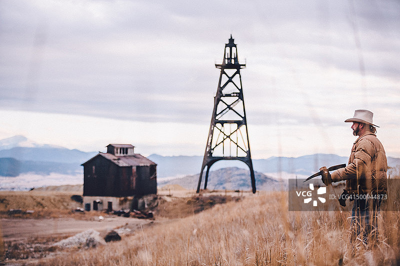 男人手持工具眺望山脉图片素材