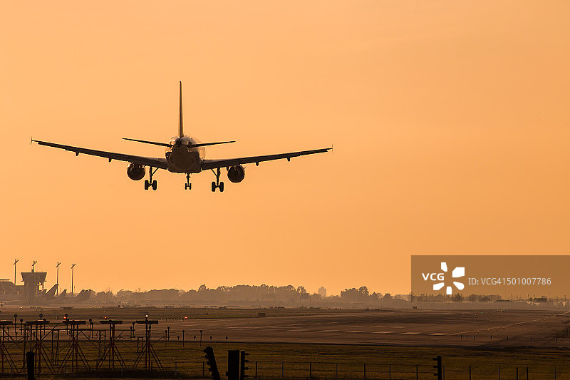 飞机在日落时分的巴塞罗那埃尔普拉特机场降落图片素材