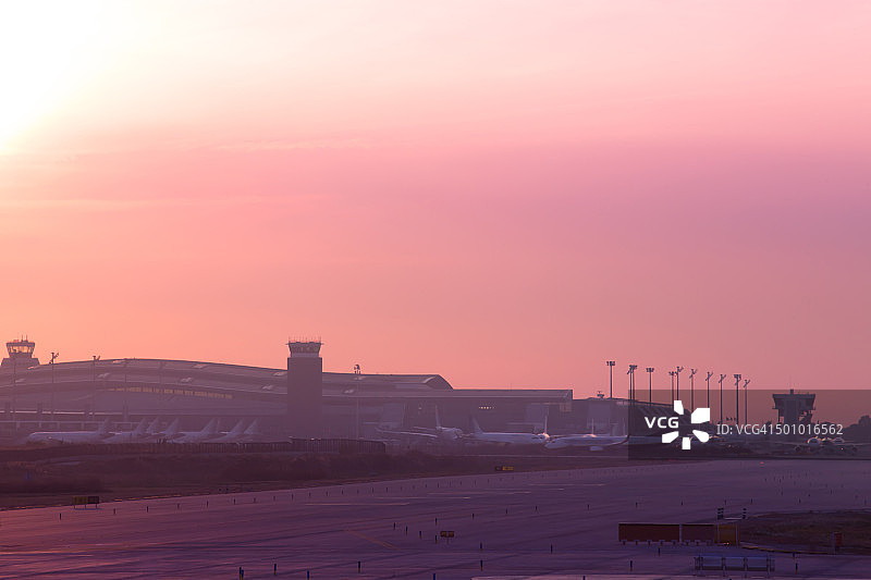 日落时分的巴塞罗那埃尔普拉特机场设施和飞机跑道图片素材