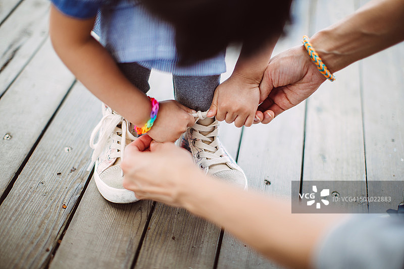 妈妈教小女孩系鞋带图片素材