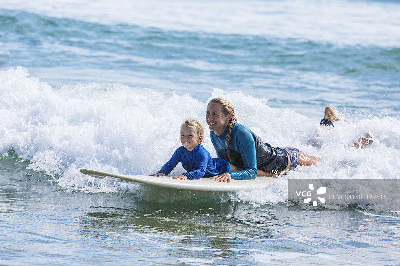 母子在海滩上冲浪图片素材