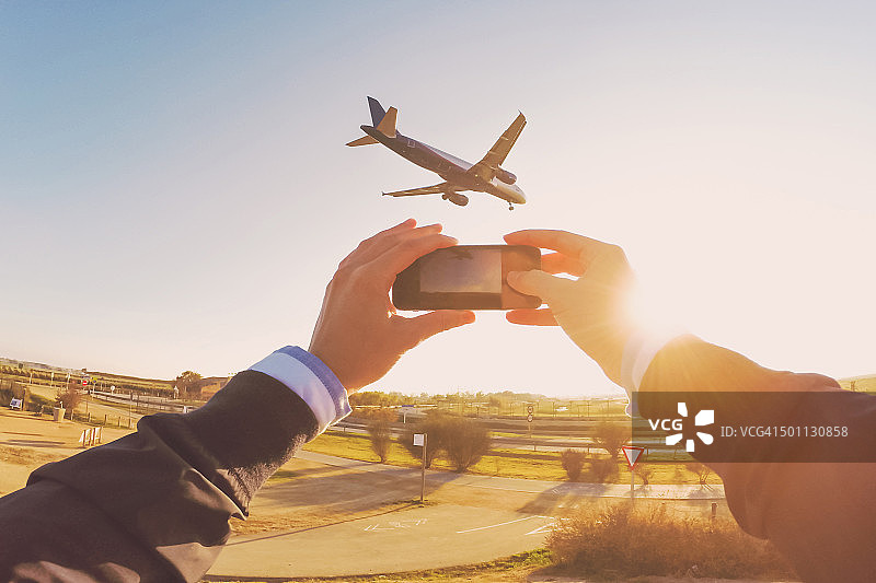 兴奋的男人举起手臂，以第一人称视角拍摄飞机图片素材