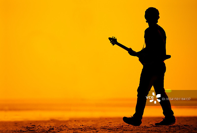 在海滩上弹吉他的男人剪影图片素材