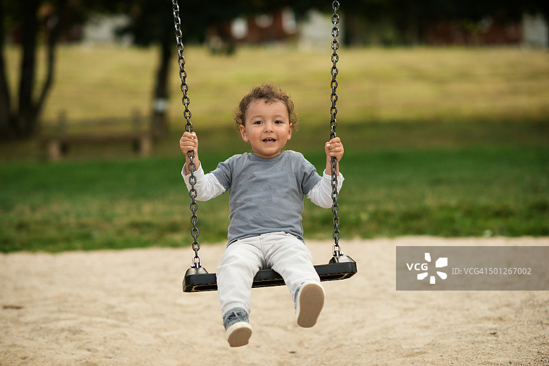 在户外荡秋千的男孩图片素材