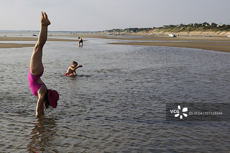 女性在水中倒立，与孩子们嬉戏图片素材