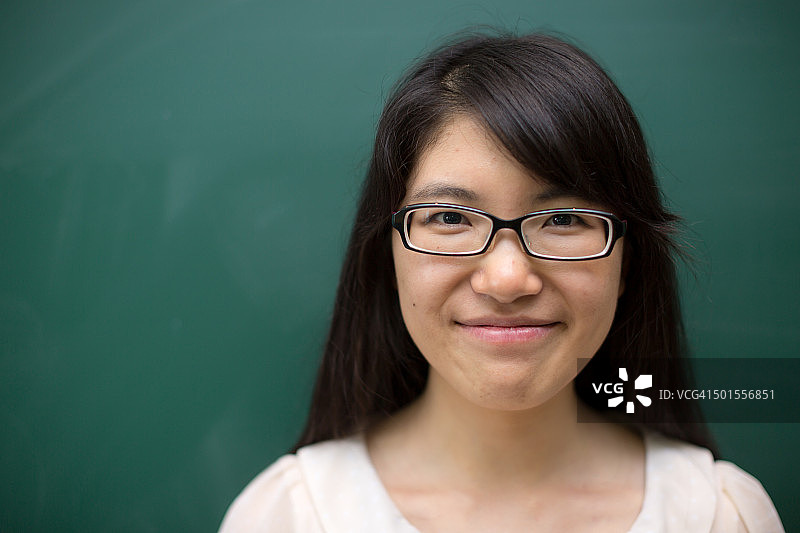 黑板前的年轻女大学生图片素材