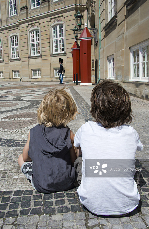 在丹麦哥本哈根，两个孩子看着阿美琳堡的皇家卫队图片素材