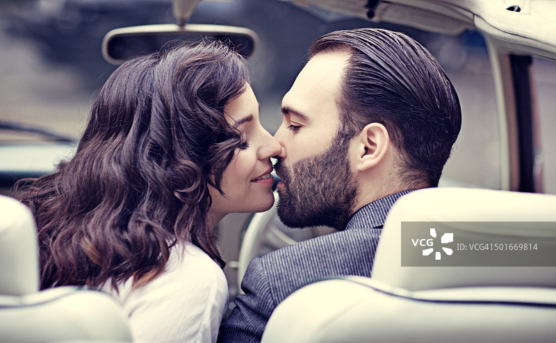 时尚复古情侣在老式汽车中亲吻图片素材