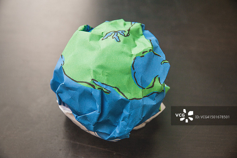 看起来像地球仪的纸球放在桌子上图片素材